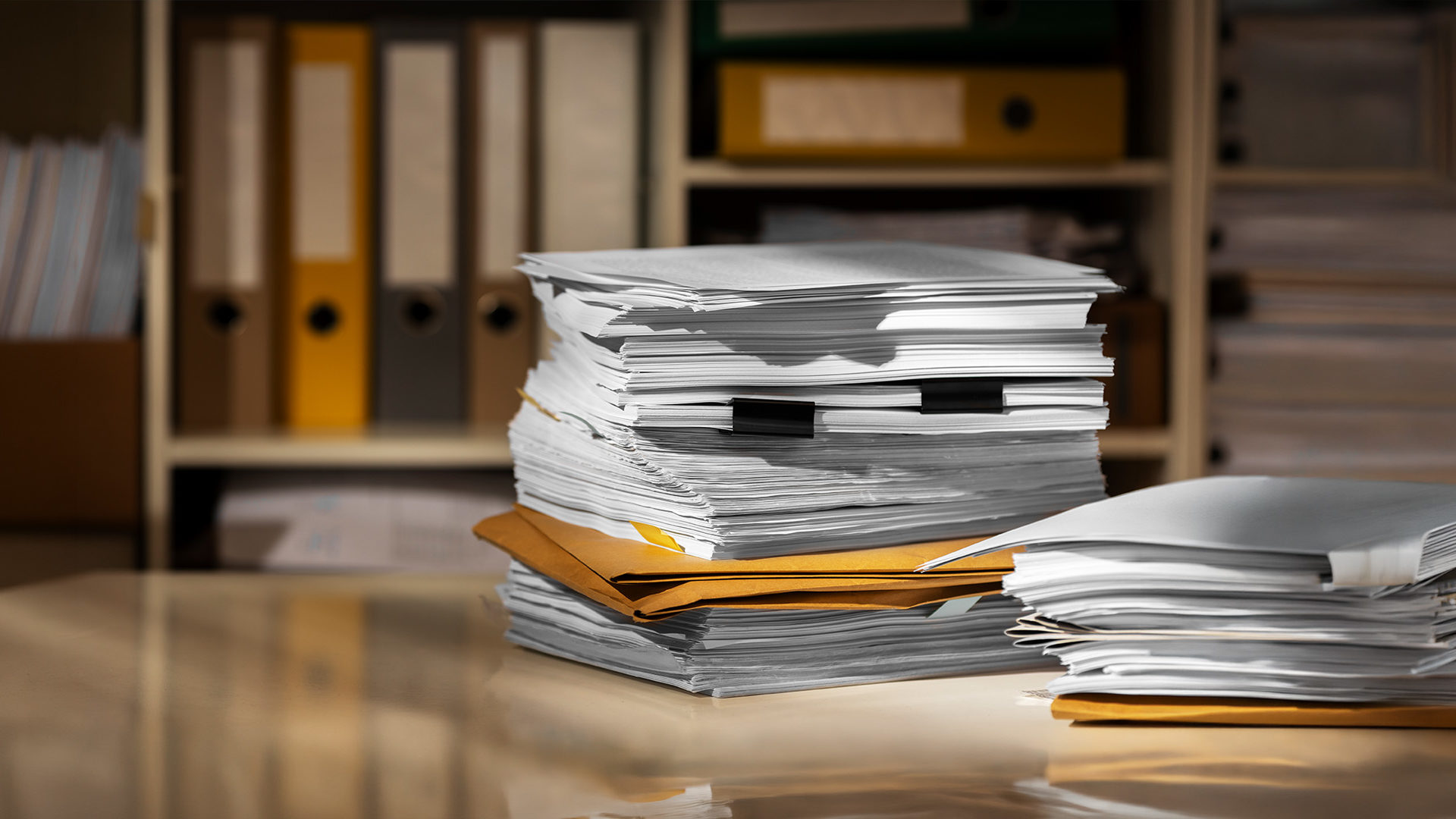 A pile of documents placed on a desk.