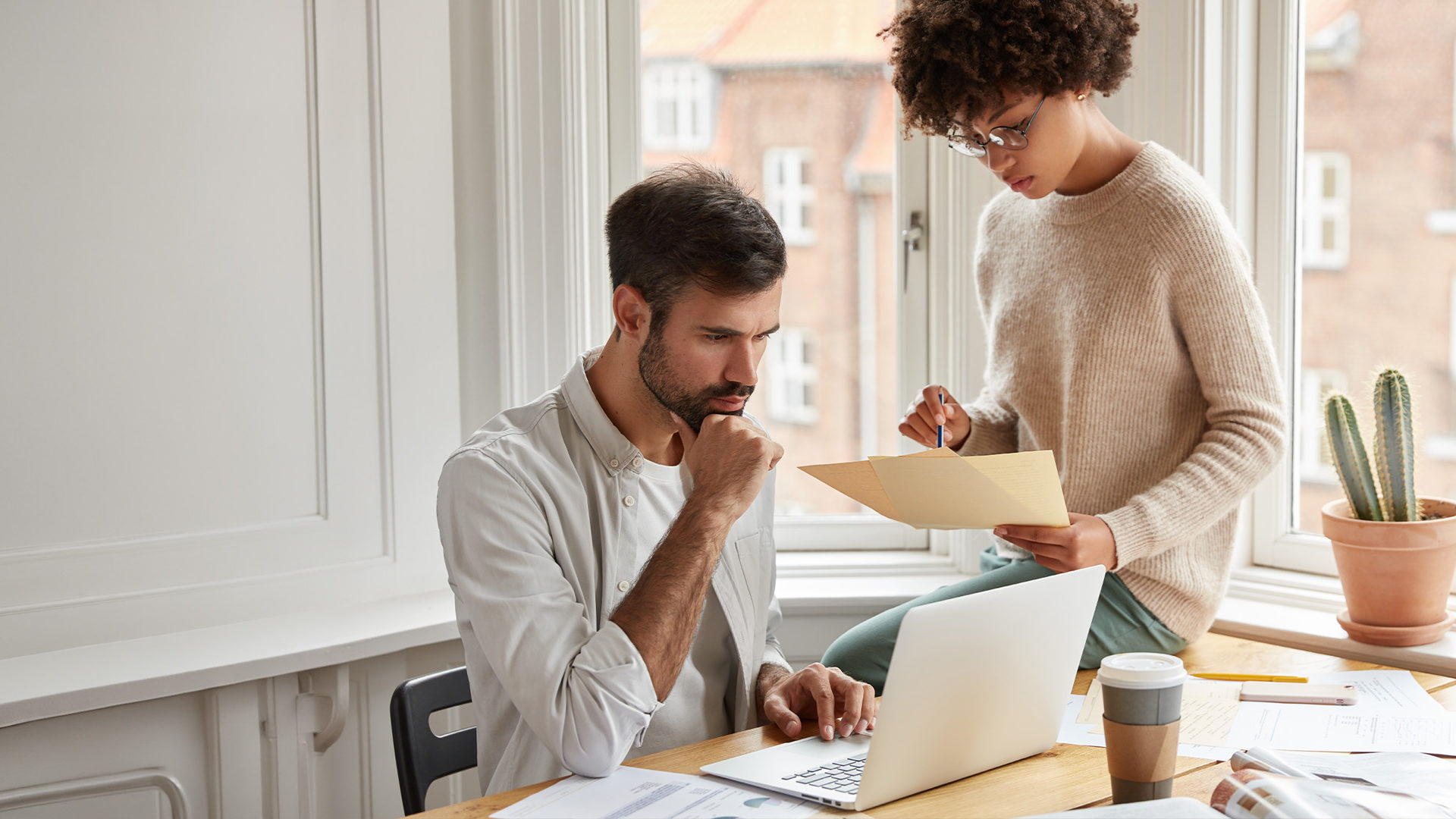 Two co-workers at a desk working on a project.