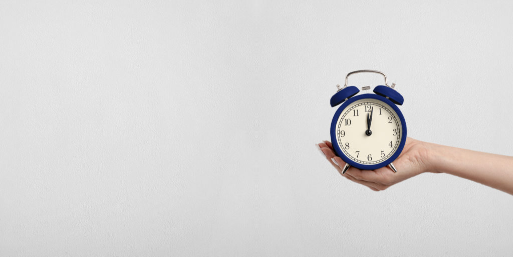 Hand holding alarm clock.